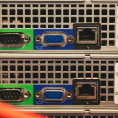 Dwa serwery z portami VGA, RJ45 i światłowodowymi. Każdy serwer ma unikalny adres MAC, widoczny na naklejkach.