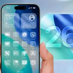 Dłoń trzyma iPhone'a z widżetami pogody i lokalizacji, obok duża, błękitna liczba 26. Czekamy, kiedy nowy iOS.