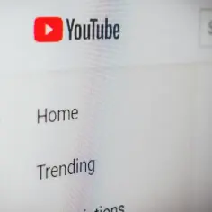 Ekran komputera z widocznym logo YouTube, menu i polem wyszukiwania.