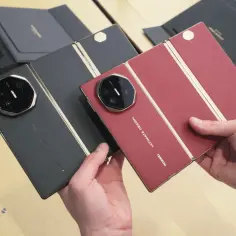Dwie składane wersje Huawei Mate XT Ultimate w kolorze czarnym i czerwonym, prezentowane przez dłonie.