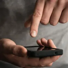 Dłoń trzyma smartfon, na którym uruchomiony jest dyktafon w telefonie.