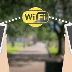 Dwie dłonie trzymają smartfony, między którymi widoczny jest symbol Wi-Fi. Połączenie **wifi direct** umożliwia szybką wymianę danych.