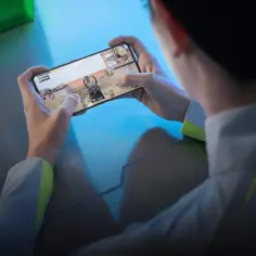 Gracz trzyma w dłoniach telefon do gier, zanurzony w wirtualnym świecie.