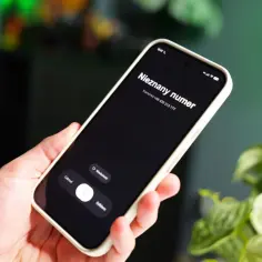 Dłoń trzyma telefon z ekranem pokazującym "Nieznany numer". Czy to numer 663 co to za numer?