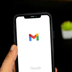 Telefon z logo Gmail i napisem Google. Dowiedz się, jak wylogować się z konta Google na telefonie, aby zwiększyć bezpieczeństwo.