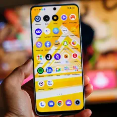 Dłoń trzyma smartfon realme z kolorowym ekranem. Chcesz wiedzieć, jak wyłączyć telefon realme? Ten ekran główny pokazuje ikony aplikacji.