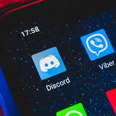 Ikona Discord na ekranie telefonu. Dowiedz się, jak dodać bota do Discorda, aby ulepszyć swój serwer.