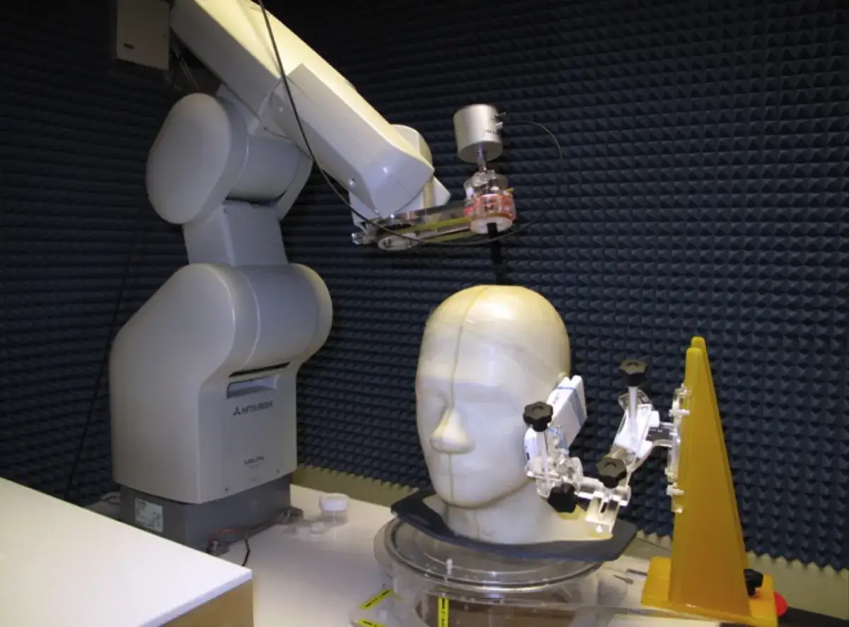 Robot mierzy SAR na manekinie głowy w komorze bezechowej.
