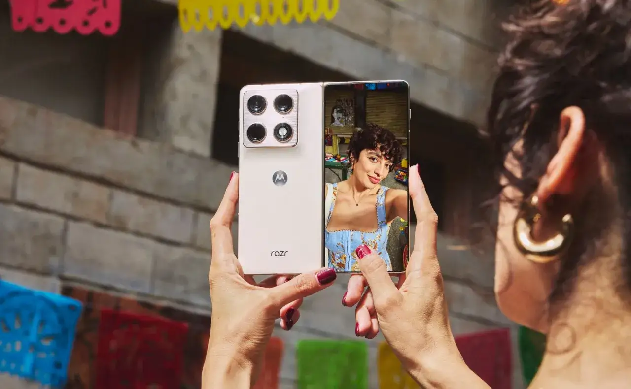 Kobieta robi selfie na ekranie składanego telefonu motorola razr fold.