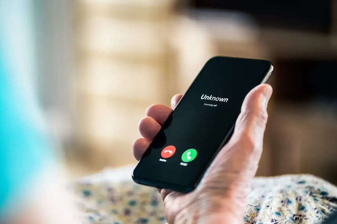 Dłoń trzyma smartfon z ekranem pokazującym