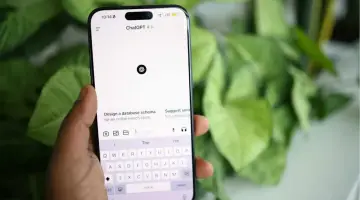 Dłoń trzyma smartfon z otwartą aplikacją ChatGPT. Możesz korzystać z ChatGPT za darmo bez logowania, pytając o pomoc w projektach.