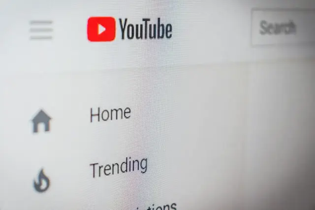 Ekran komputera z widocznym logo YouTube, menu i polem wyszukiwania.